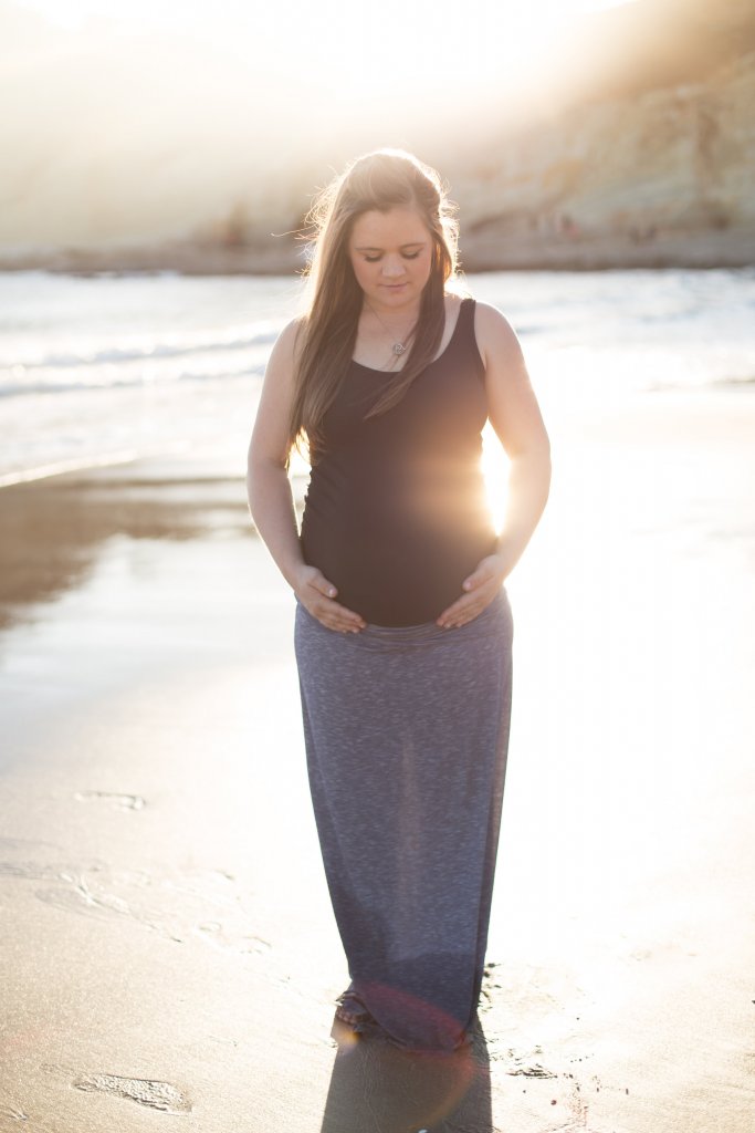 maternity photo shoot at the beach holding belly bright sun maternity photo shoot at the beach holding belly bright sun