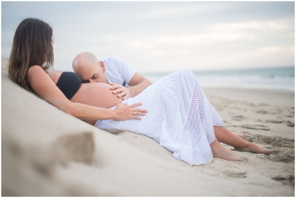 maternity photo shoot at the beach laying down kissing belly maternity photo shoot at the beach laying down kissing belly