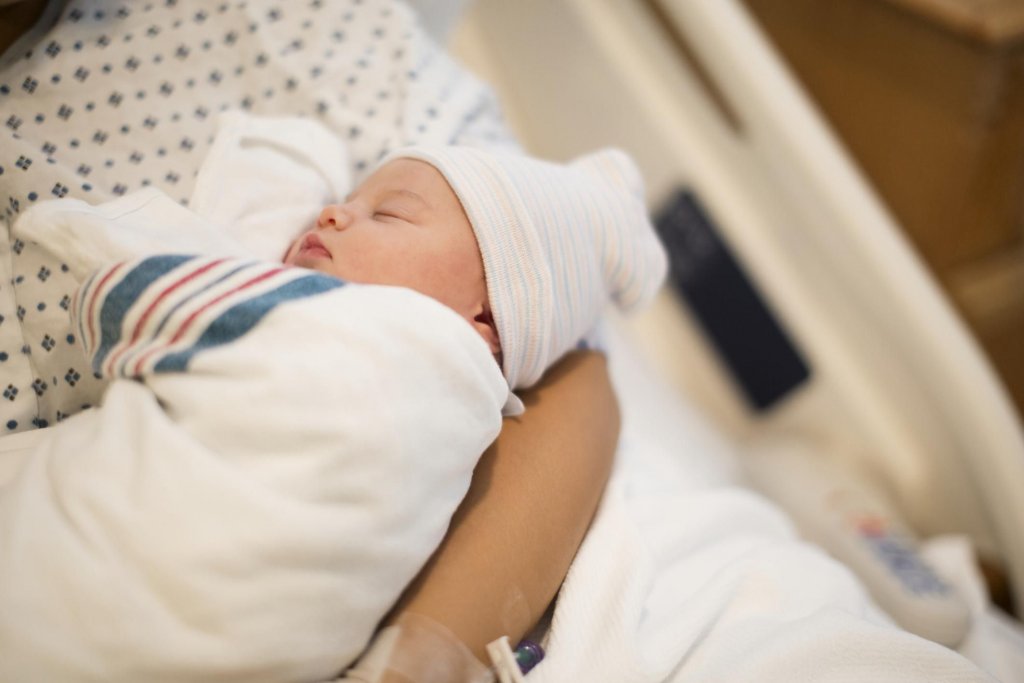 newborn sleeping in mothers arm newborn sleeping in mothers arm