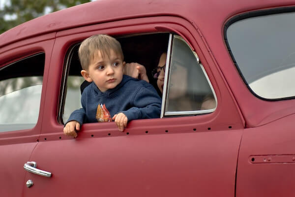 A toddler in a vintage car